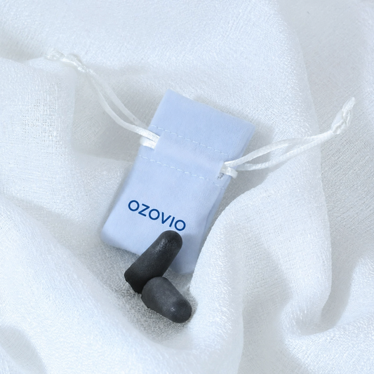 Tapones antirruido OZOVIO de espuma con su bolsa de tela azul claro sobre una sábana blanca